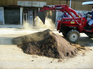 トラクターのバケットを使って用土を混合しています