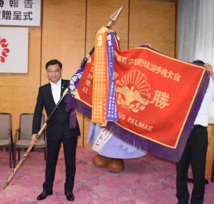 優勝旗の重みを実感する小林議長の写真