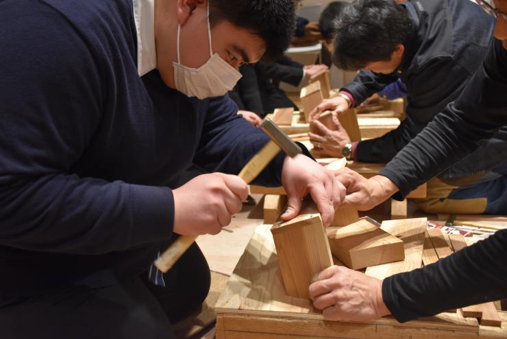 かなづちでプランターを作る男性