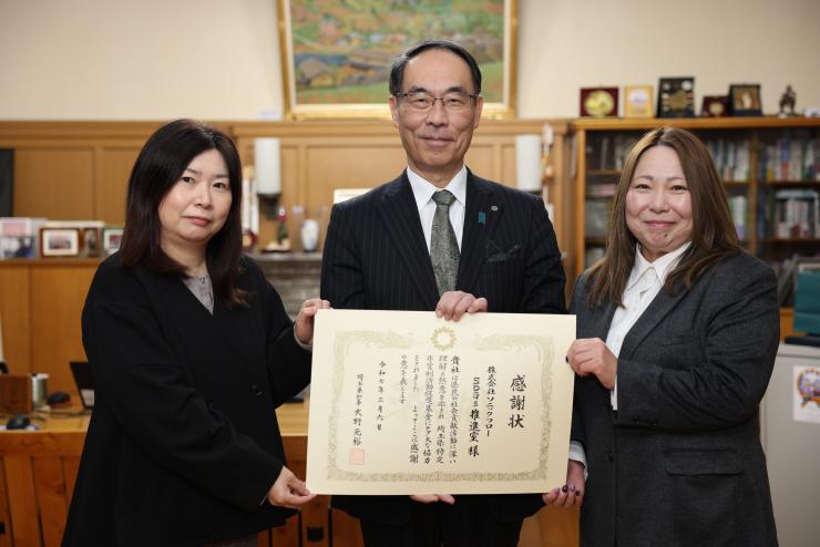 感謝状贈呈式で株式会社ソニックフロー出席者と記念写真を撮る知事の写真