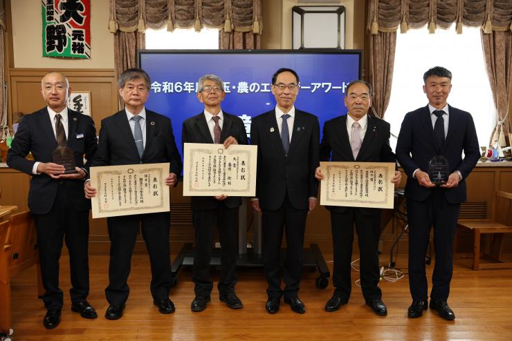 表彰式で訪問者と記念写真を撮る知事の写真