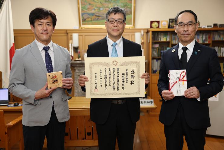 感謝状贈呈式で訪問者と記念写真を撮る知事の写真
