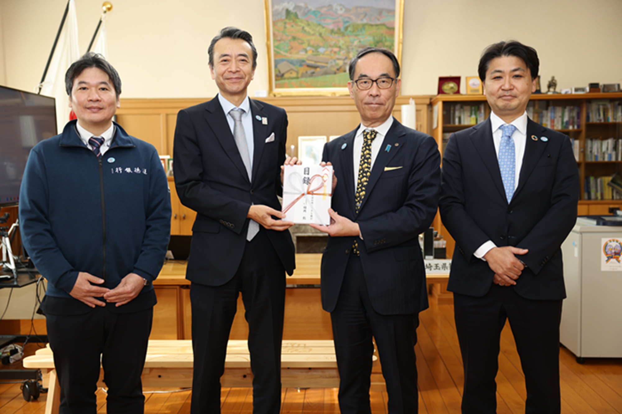 寄附していただいた株式会社りそな銀行代表者と記念写真を撮る知事の写真