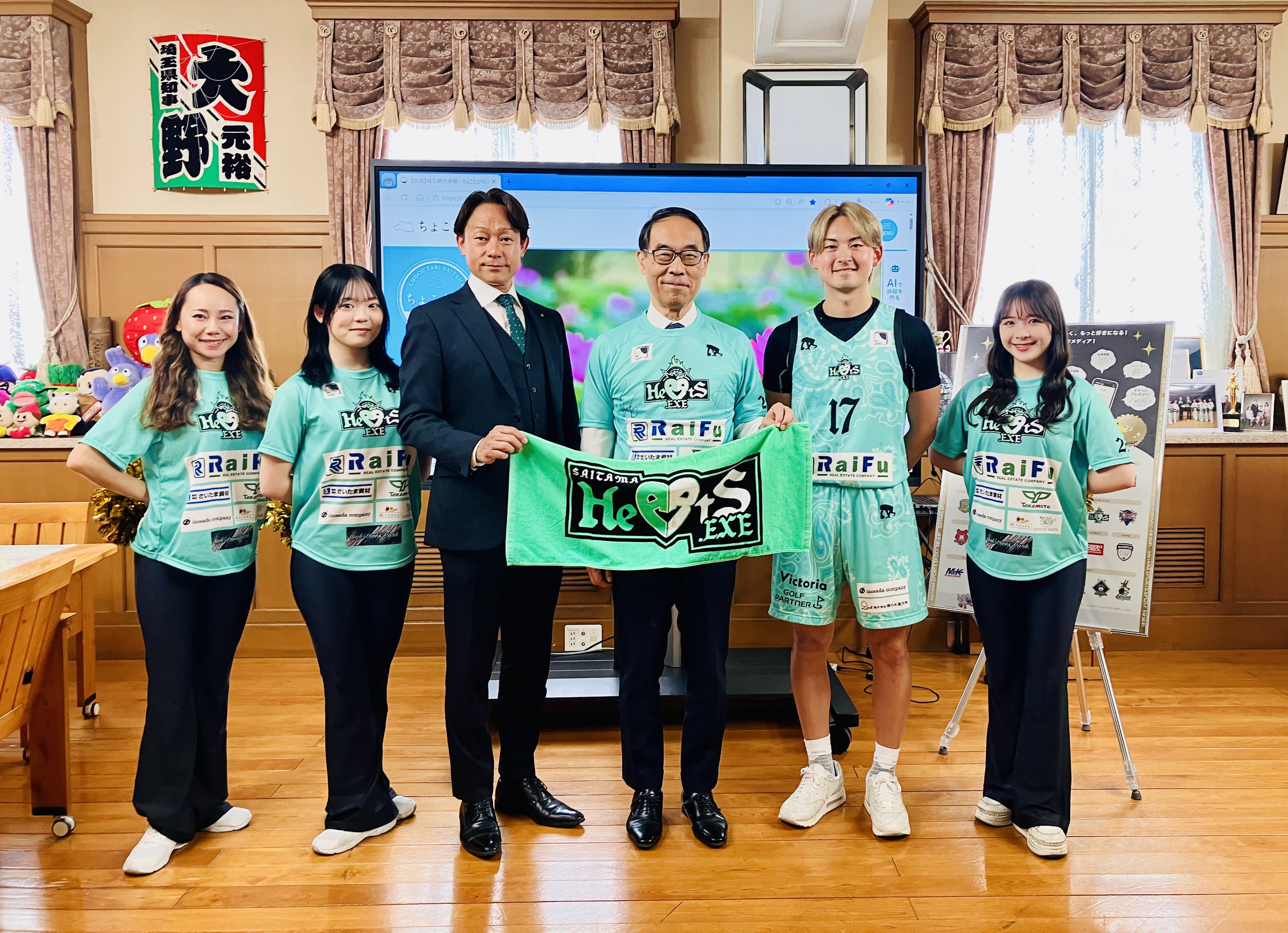 訪問者と記念写真を撮る知事の写真