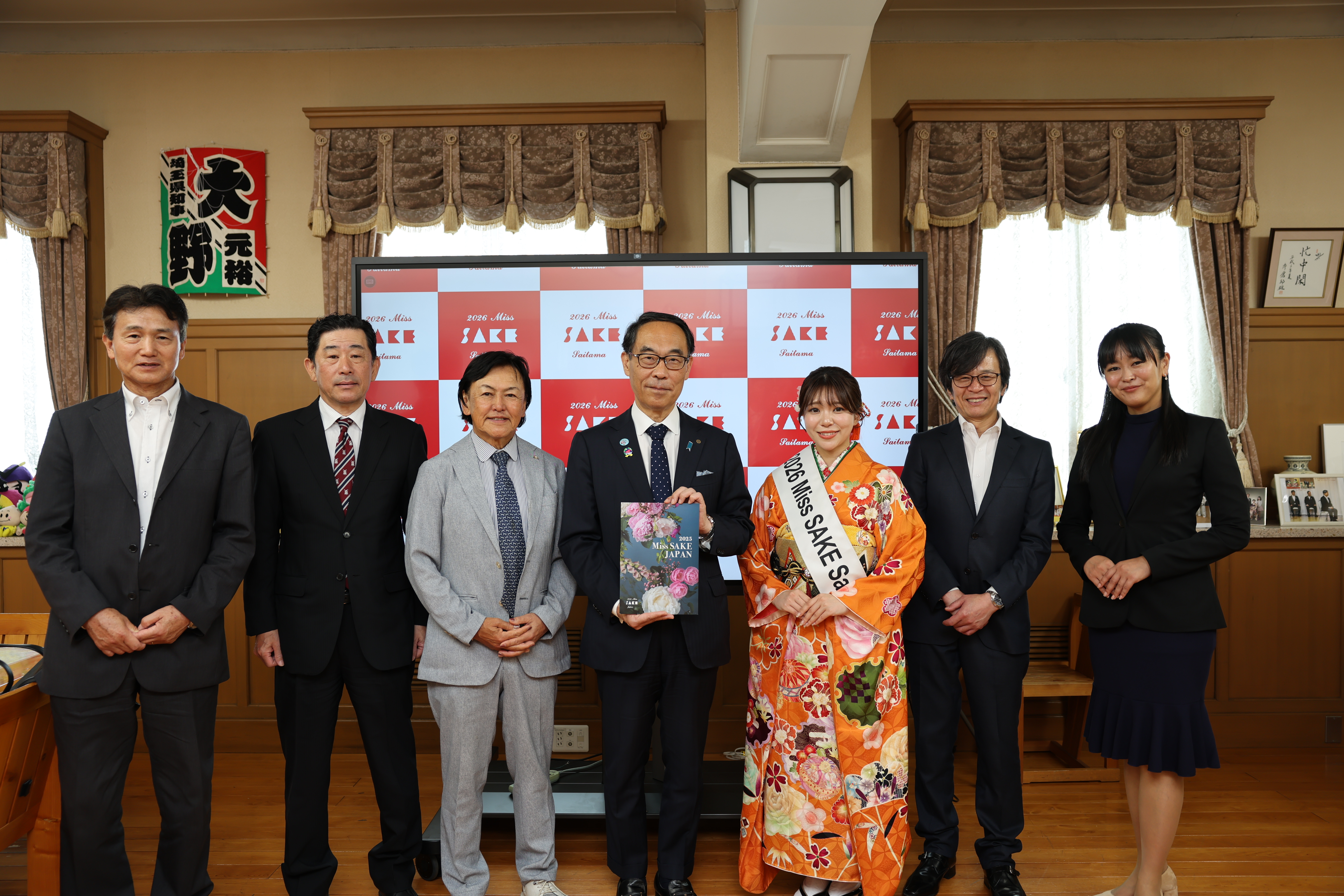 訪問者と記念写真を撮る知事の写真