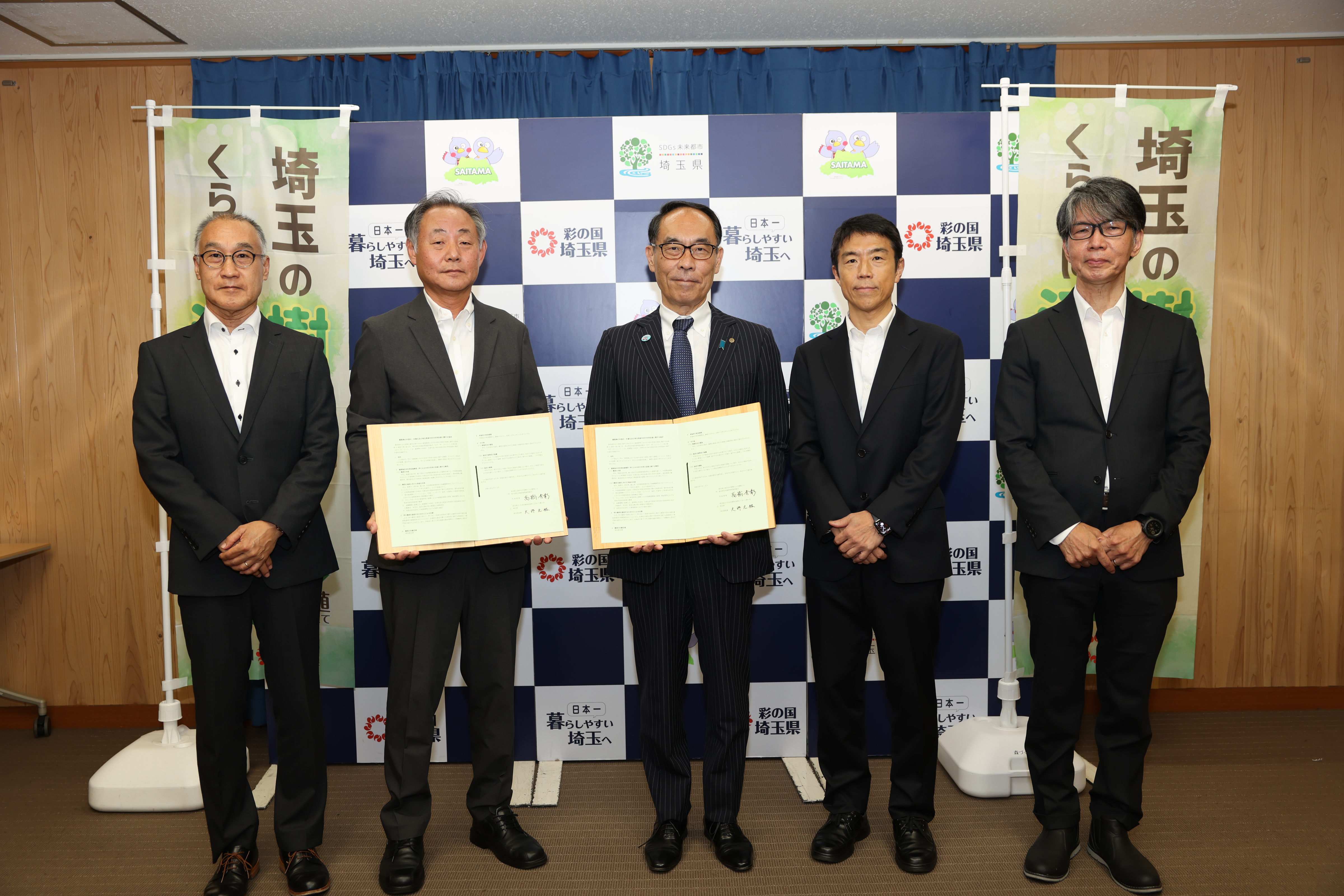 協定締結者と記念写真を撮る知事の写真