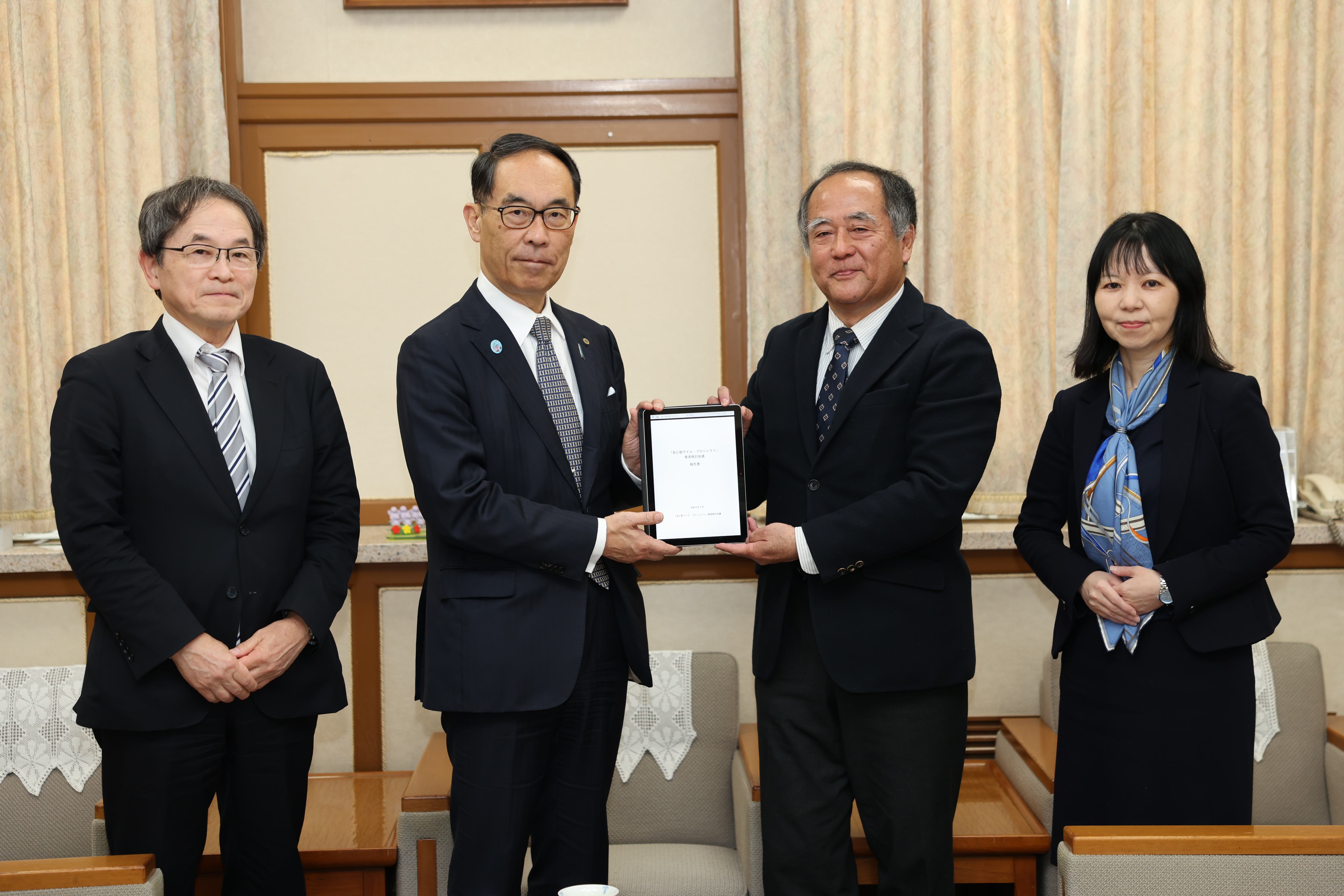 知事報告で出席者と集合写真を撮る知事の写真