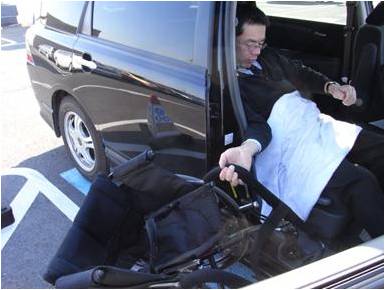 車いすドライバーが、車いすを自動車の中に収納しようとしている写真です。