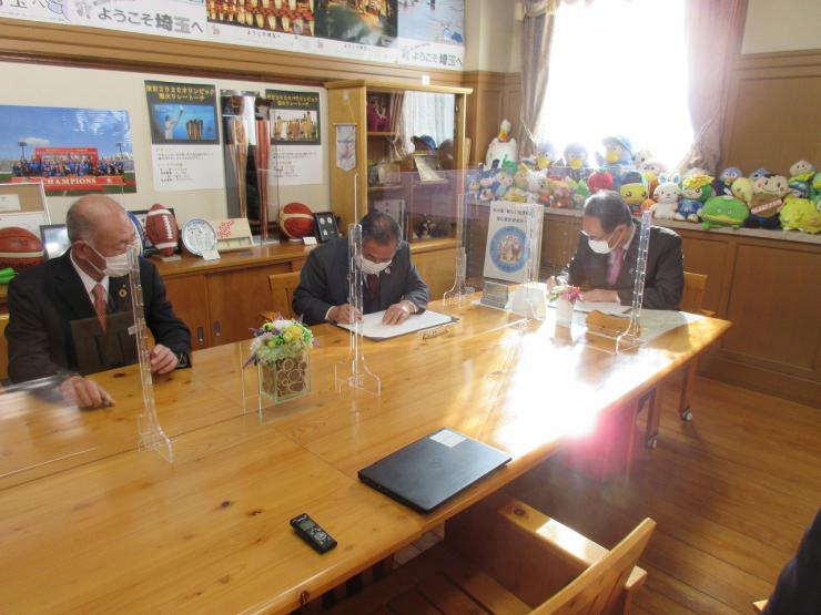 農業振興に関する連携協定締結式で署名する知事