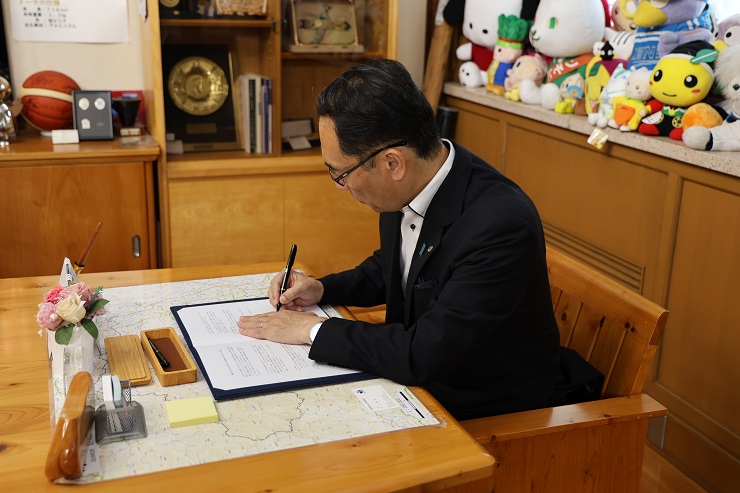 書類にサインをする知事