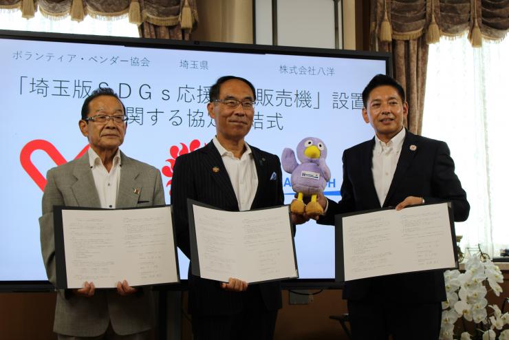 「埼玉版SDGs応援自動販売機」設置に関する協定締結式で記念撮影する知事の写真