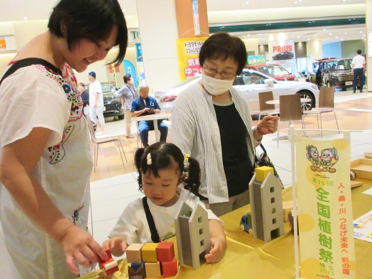 三世代で木のおもちゃで遊んでいる様子