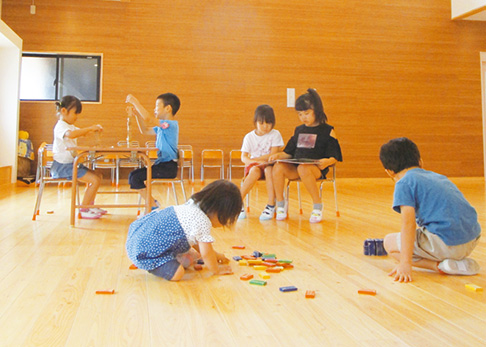 木のぬくもりを感じながら遊ぶ子供たちの写真