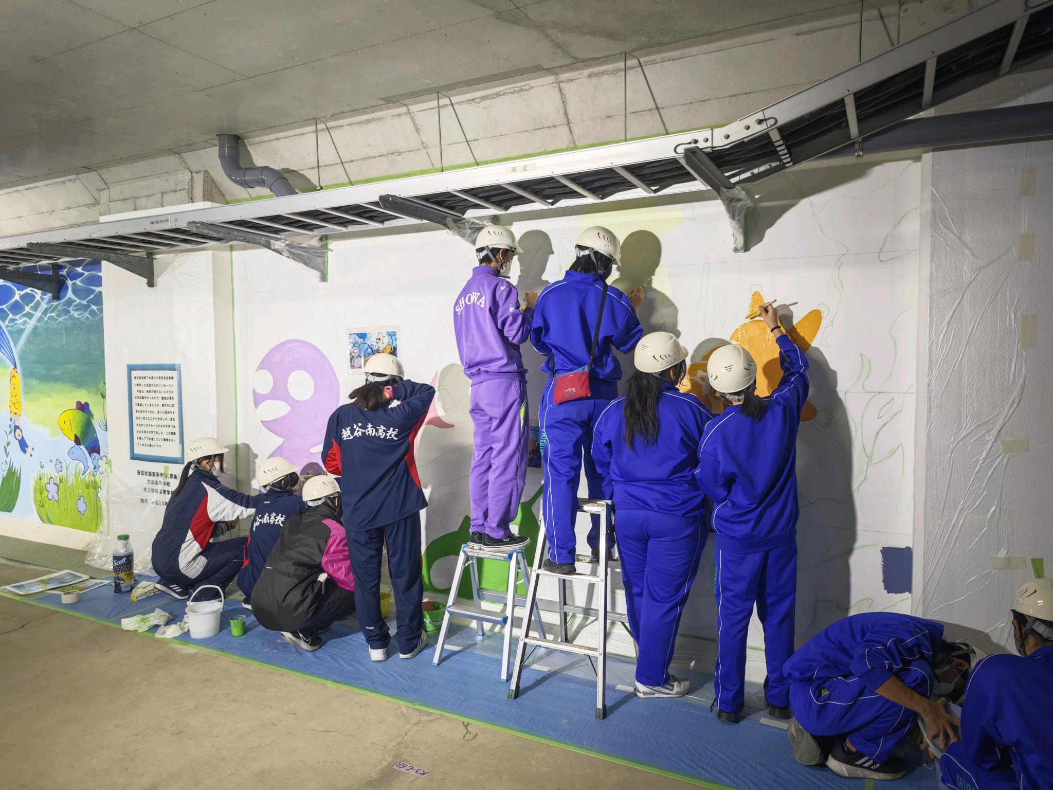戸田市にある荒川水循環センターの壁画を描く高校生の様子の写真