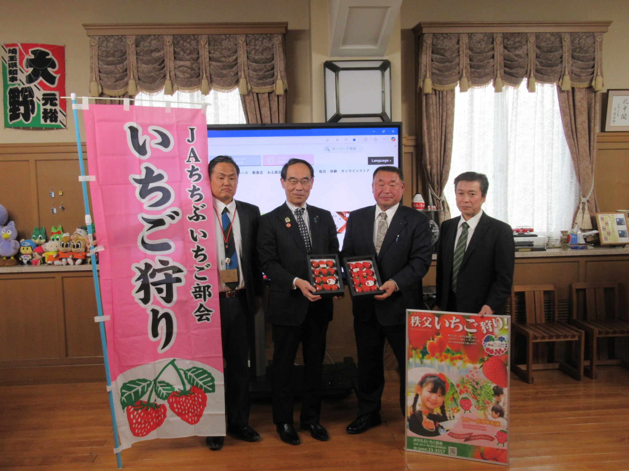 表敬訪問で訪問者と記念撮影をする知事の写真