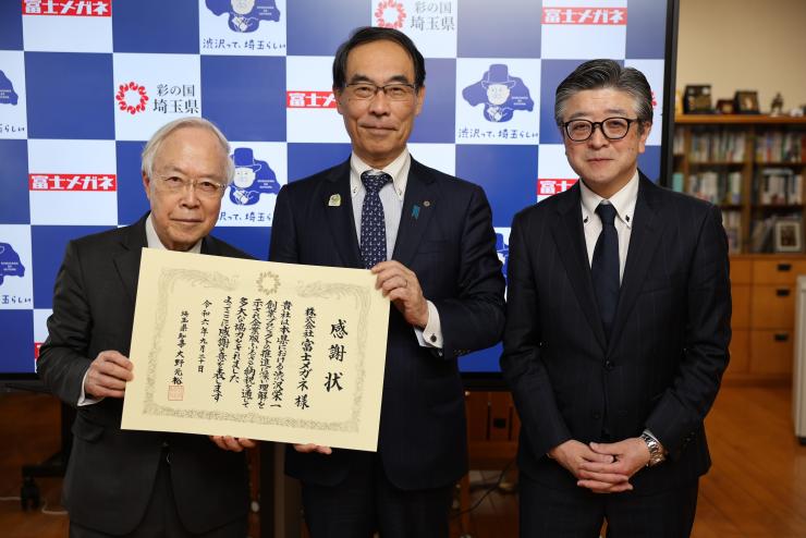 感謝状贈呈式で訪問者と記念撮影をする知事の写真