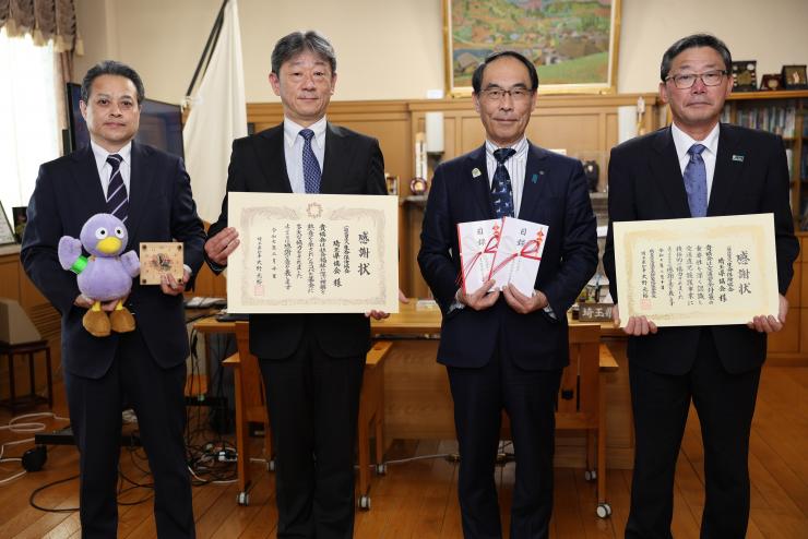 感謝状贈呈式で訪問者と記念撮影をする知事の写真