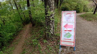 ツツジ園地入口に設置してある縦看板。看板の左側に、下に下がっている小径がある。