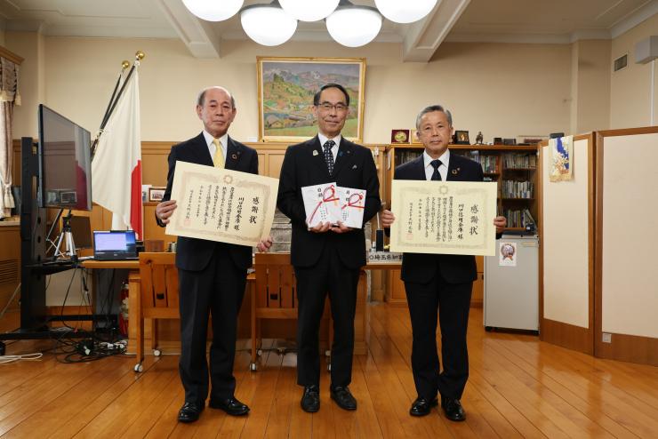 感謝状贈呈式で訪問者と記念撮影をする知事の写真