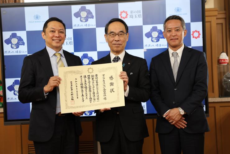 表敬訪問で訪問者と記念写真を撮る知事の写真