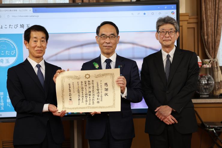 表敬訪問で訪問者と記念写真を撮る知事の写真