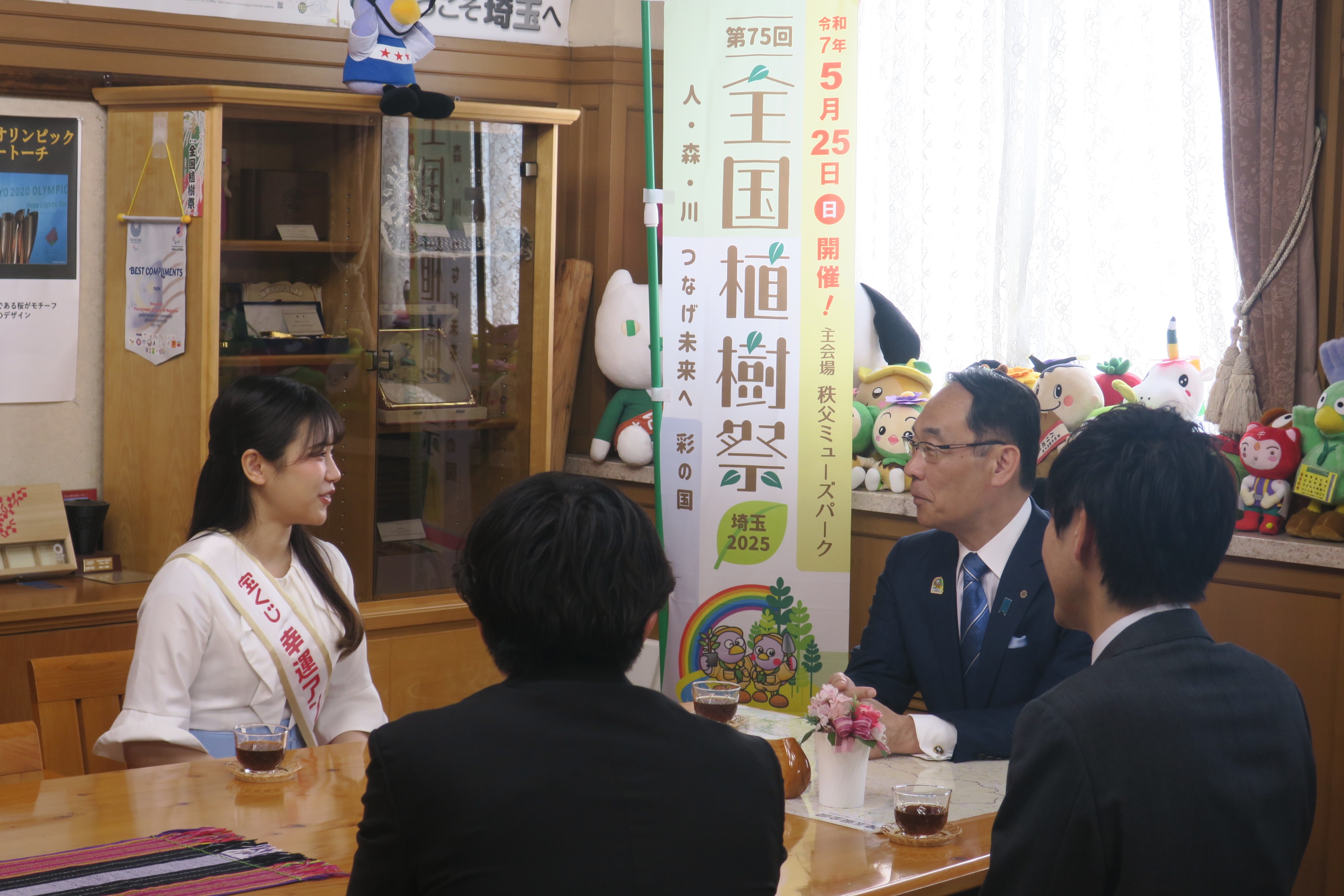 表敬訪問で訪問者（幸運アンバサダー小野田百合さんら）と歓談する知事の写真