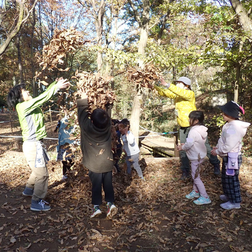 親子で里山の中で遊ぶ様子の写真