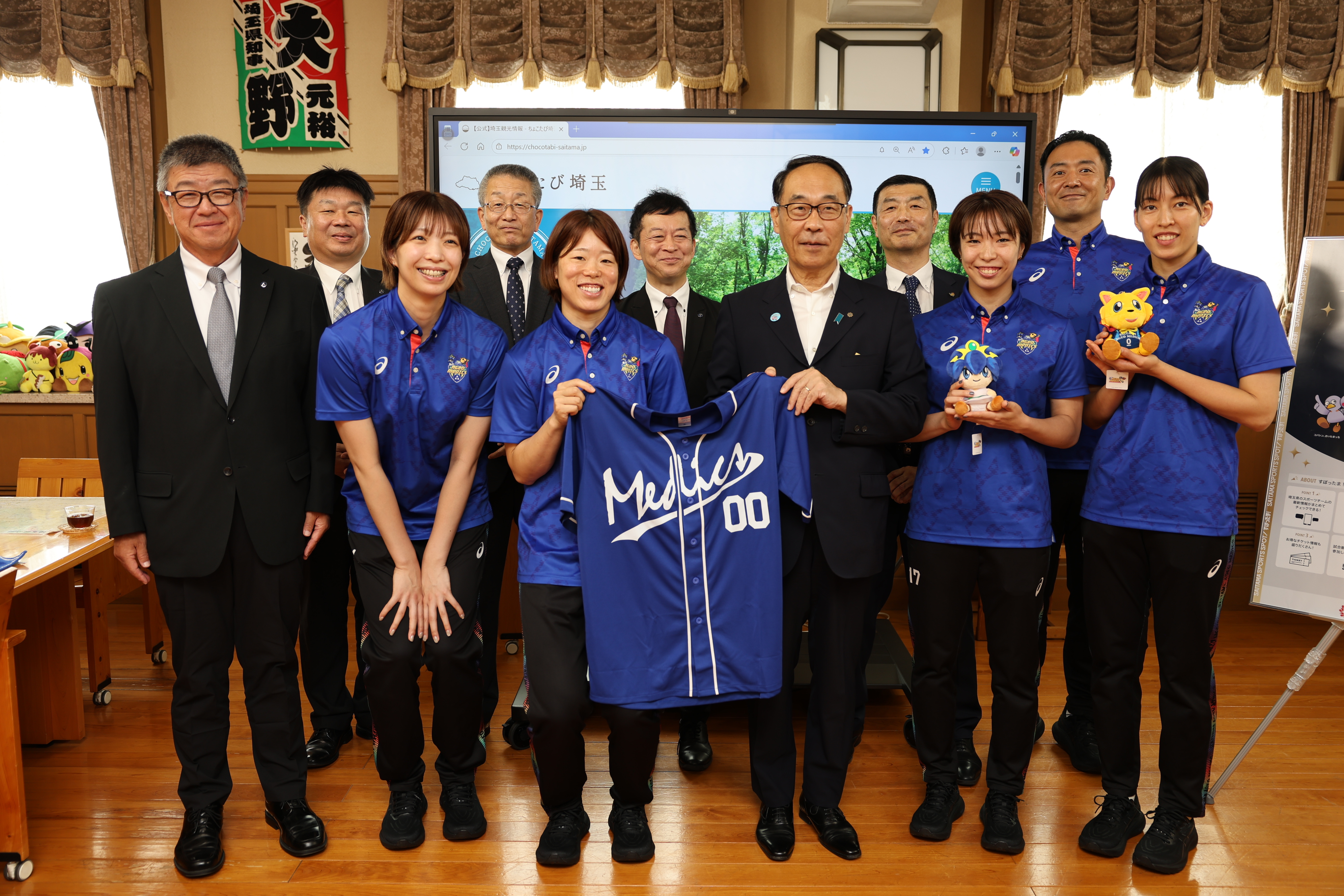 表敬訪問で訪問者と集合写真を撮る知事の写真