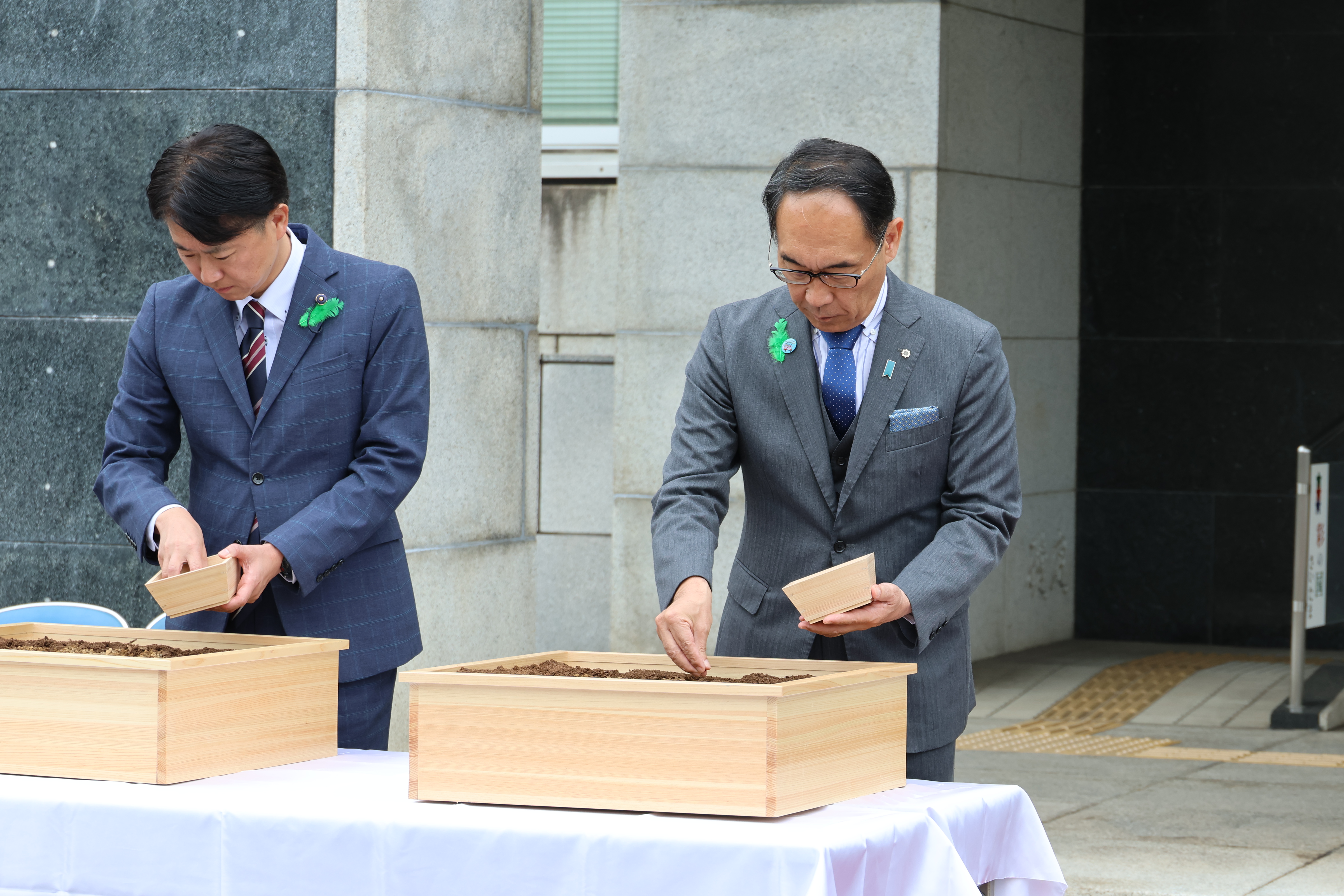 全国植樹祭植樹式で関係者と植木鉢に種をまく知事の写真
