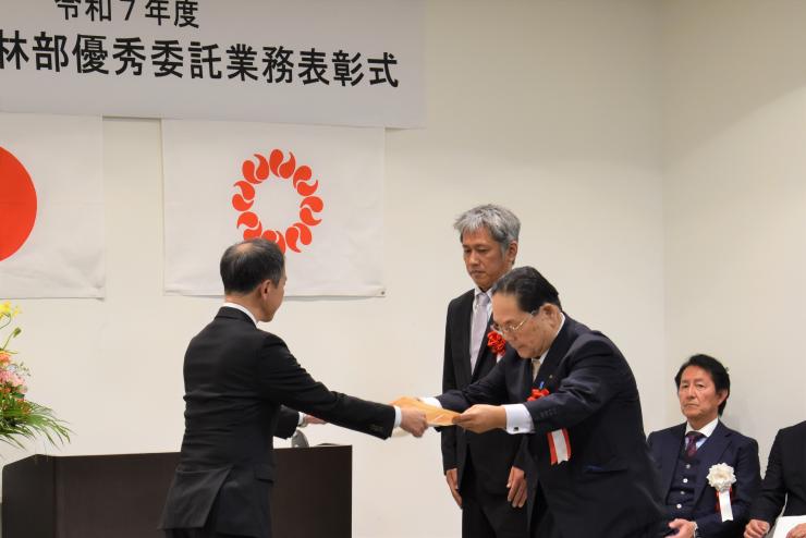 表彰状授与（松澤農林部副部長（左）と株式会社坂田測量設計事務所坂田代表取締役（右））
