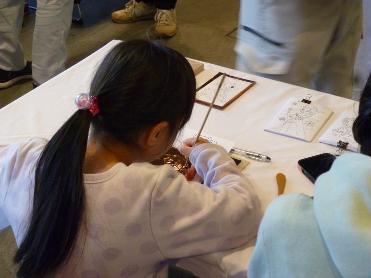 銅板でレリーフを作るこども