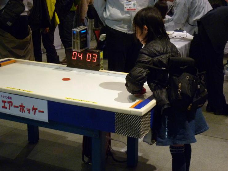 エアーホッケーで遊ぶこども