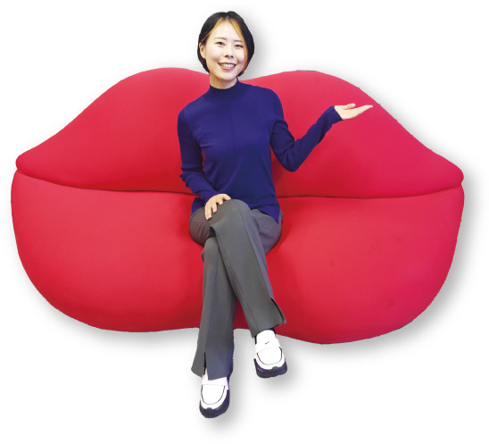 スタジオ65《ボッカ（口）》(1970年)に座る佐伯綾希学芸員の写真