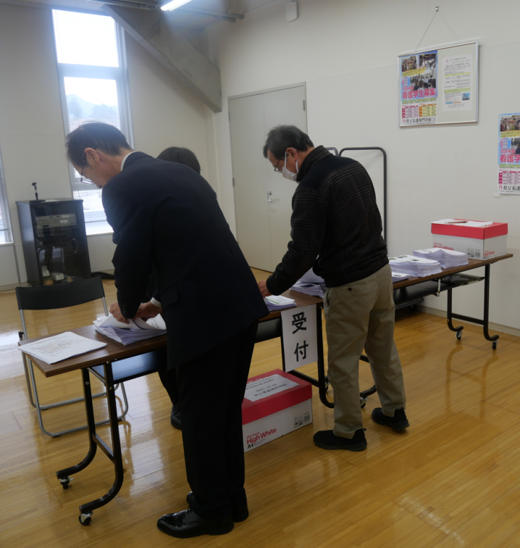 写真：運営スタッフの皆さんと資料を組む様子