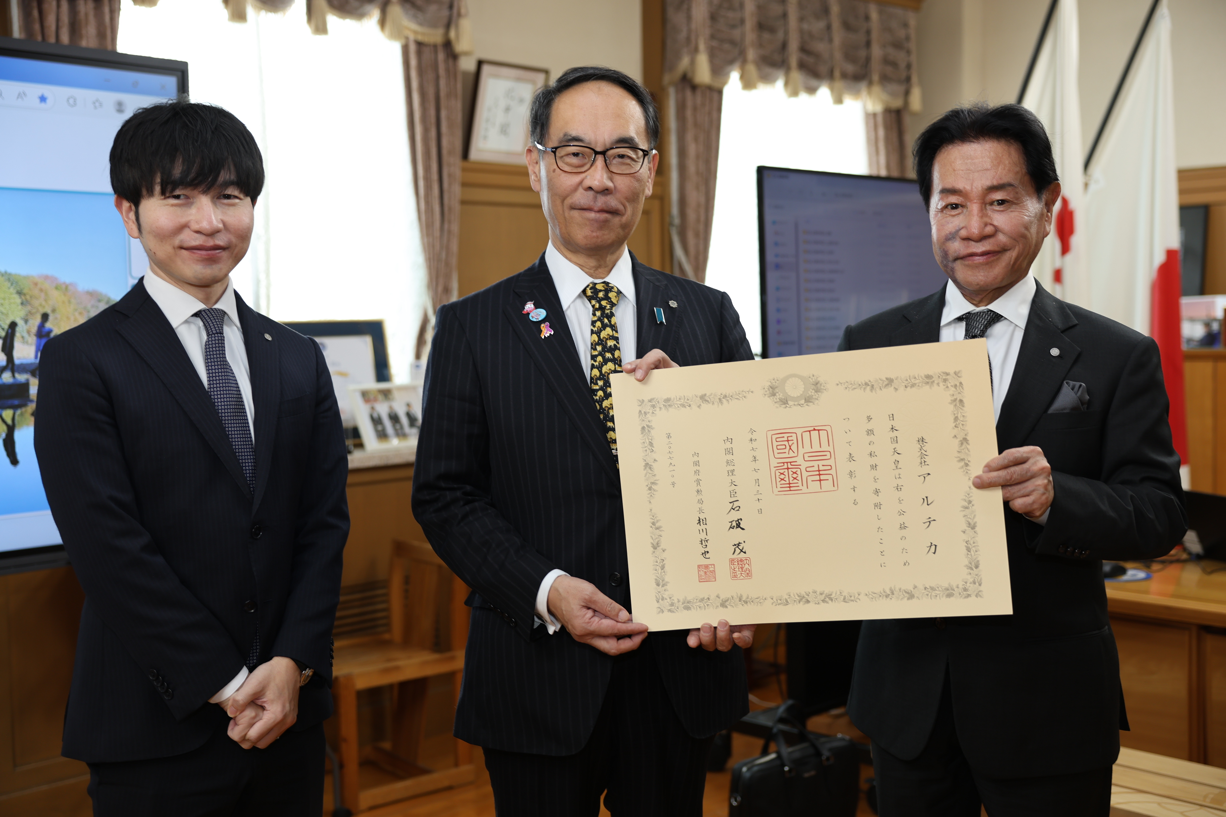 褒章者と記念写真を撮る知事の写真