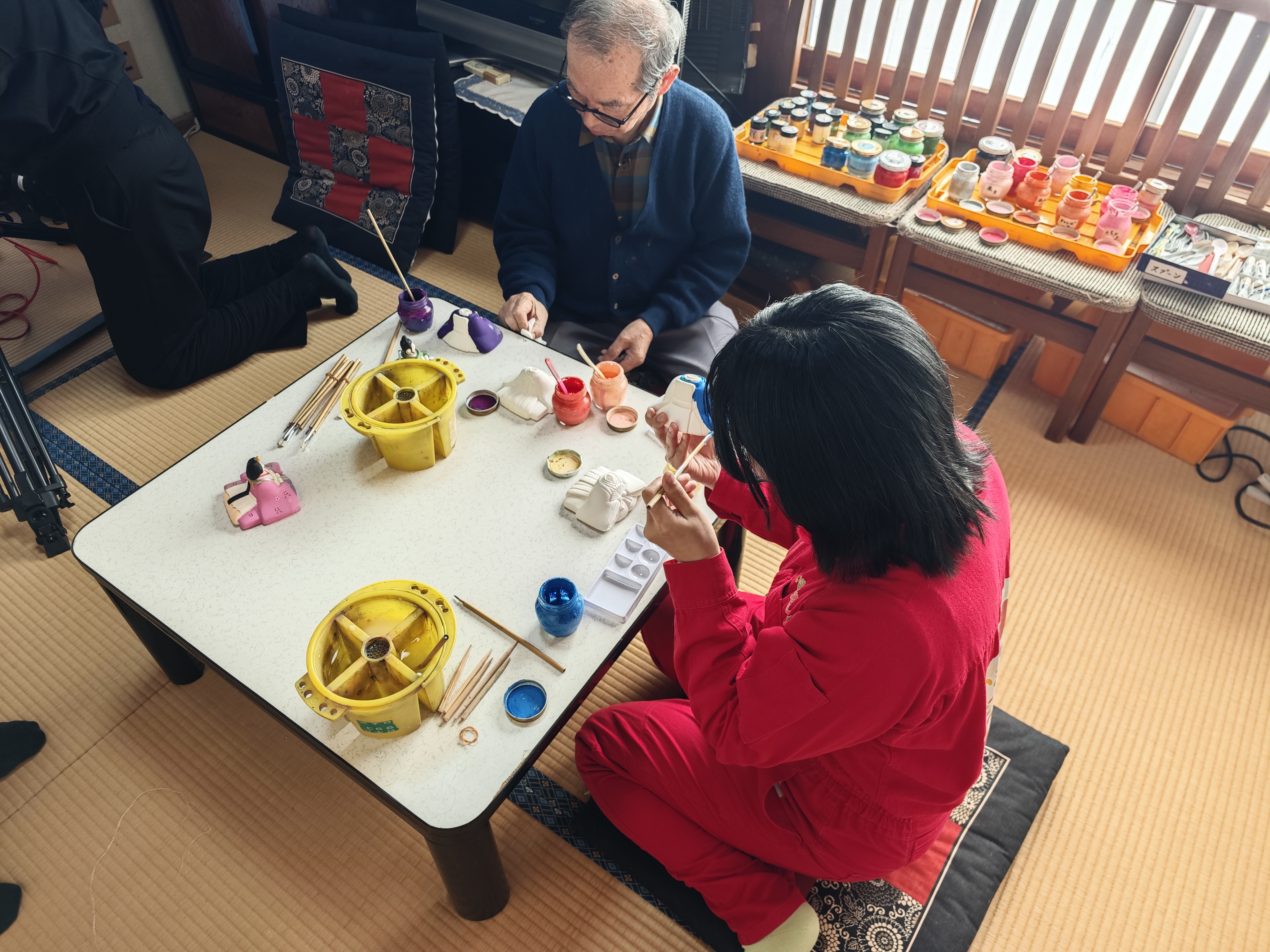 アンゴラ村長が的場人形工房で人形の絵付けを行う