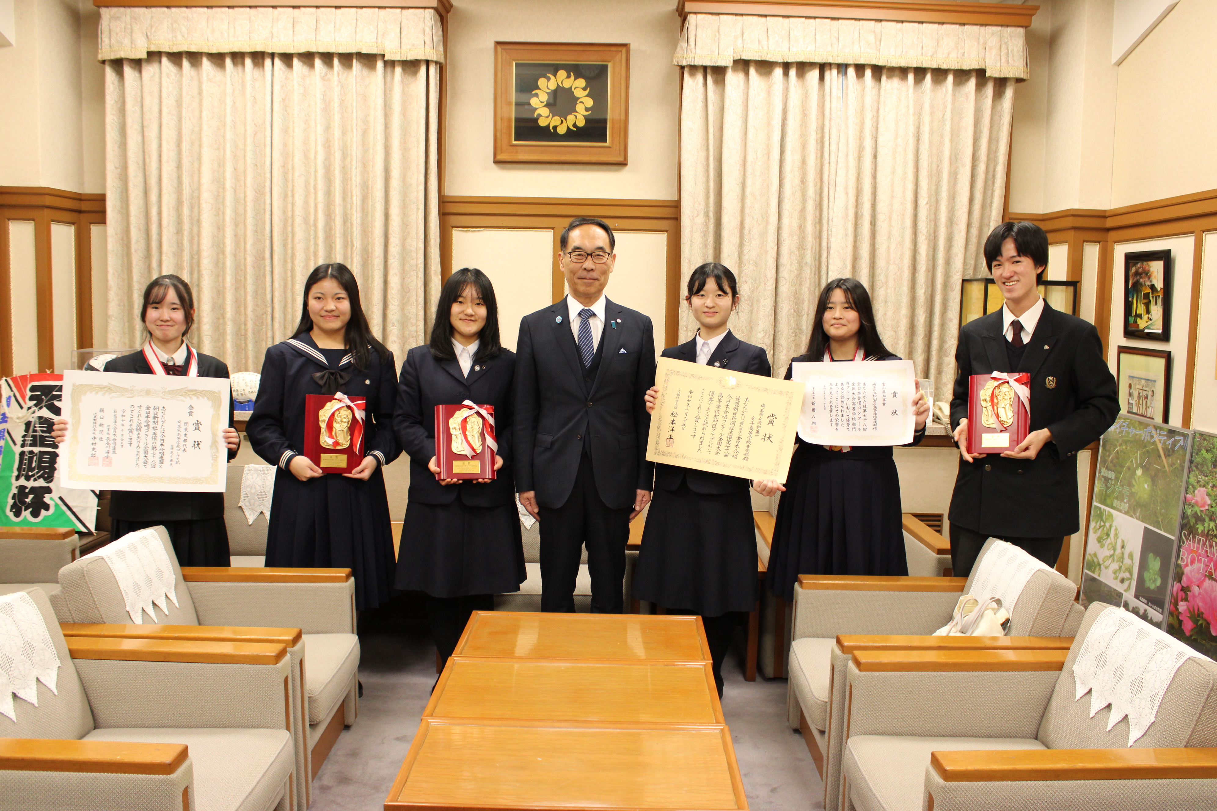 表敬訪問者と記念写真を撮る知事の写真