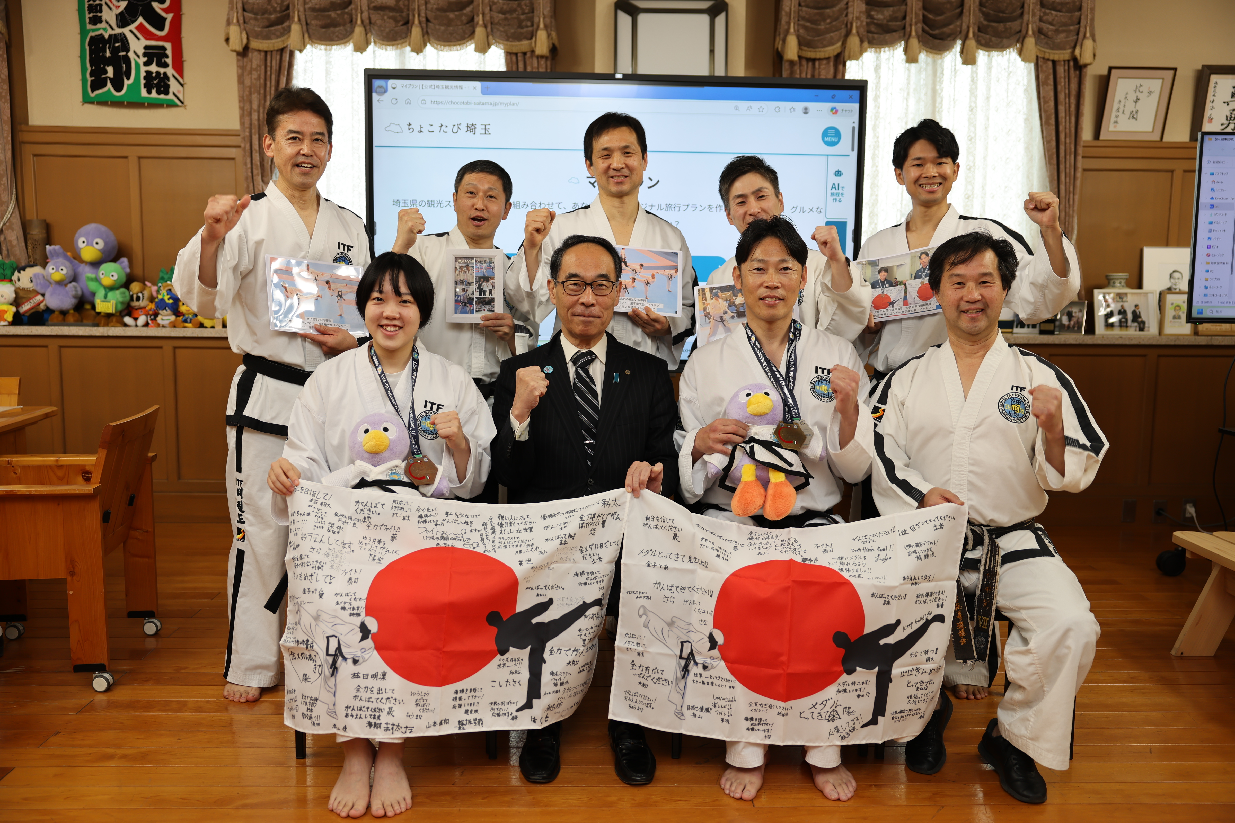 訪問者と記念写真を撮る知事の写真