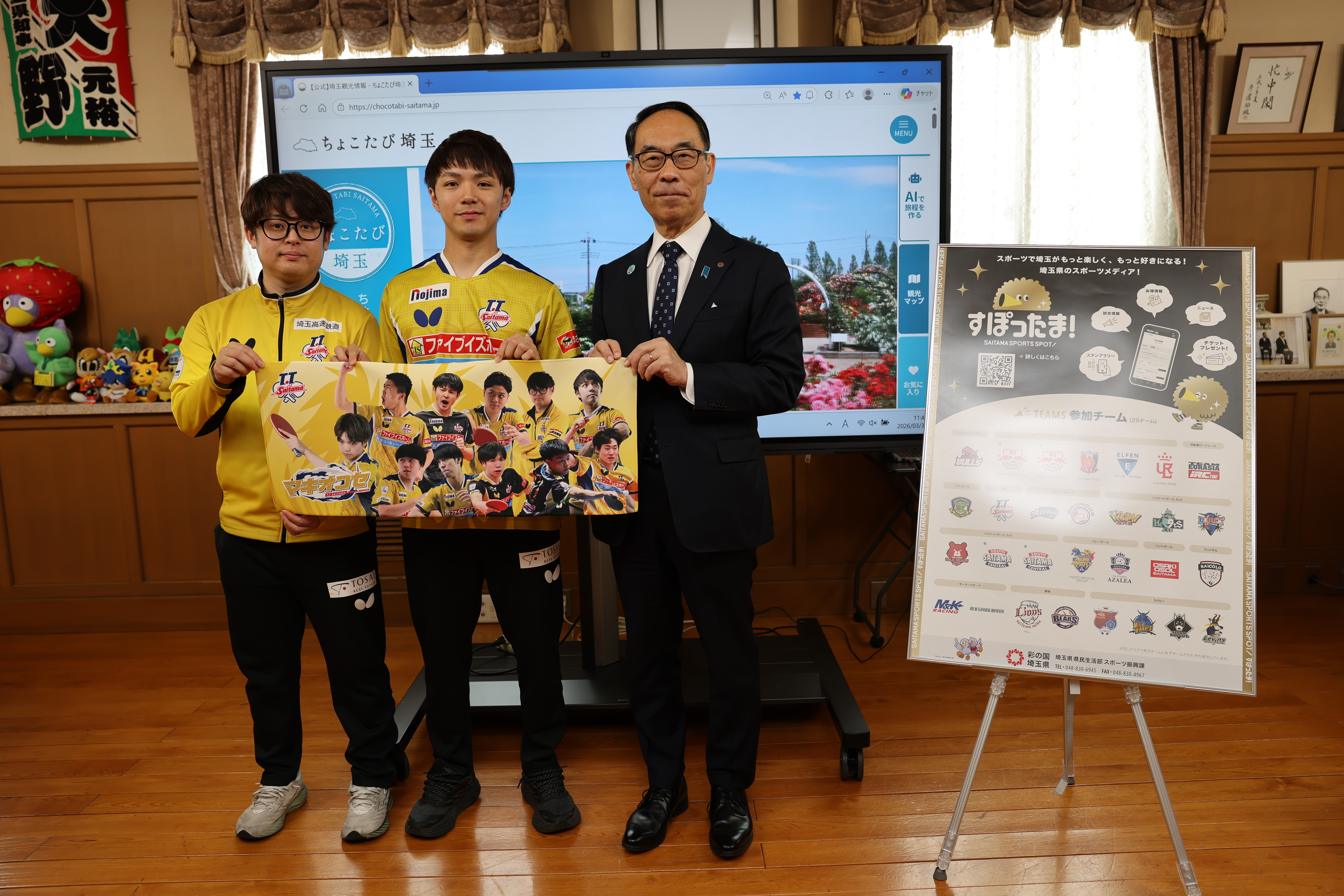 訪問者と記念写真を撮る知事の写真