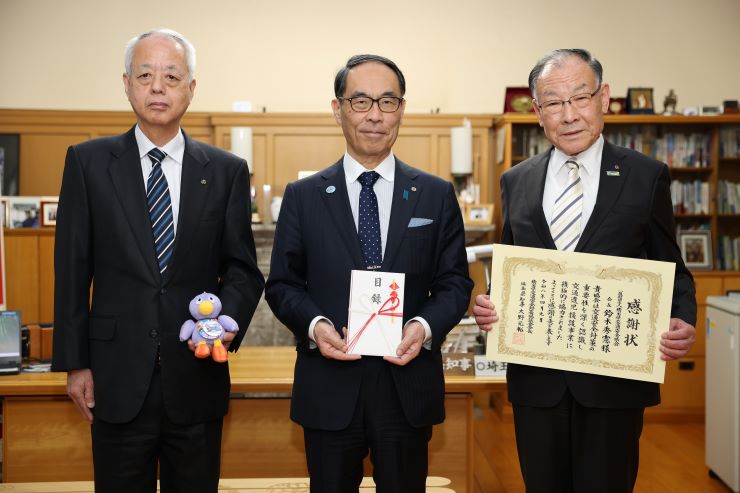 寄附いただいた方々と記念撮影を取る知事の写真