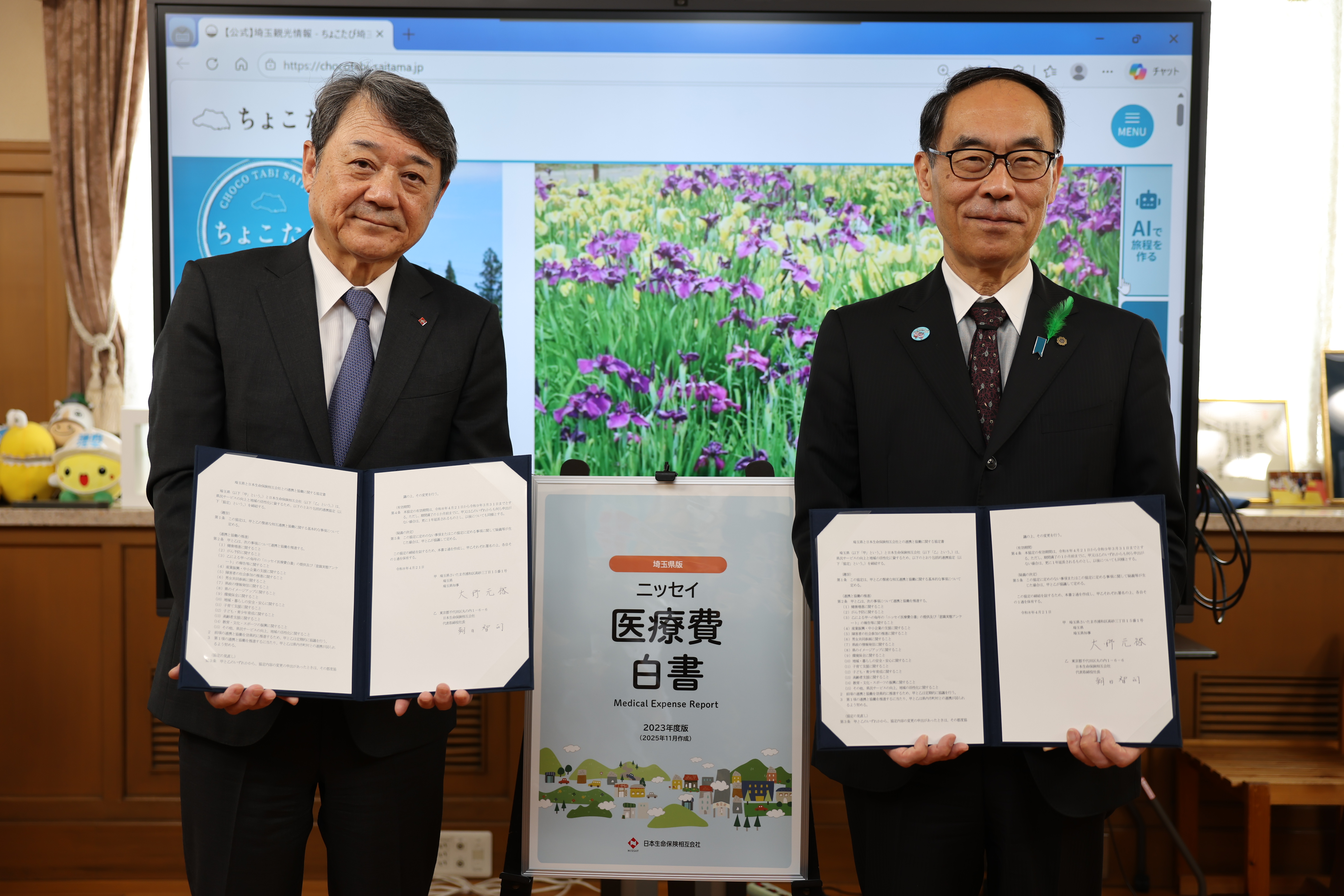 包括的連携協定の変更締結式で締結者と記念写真を撮る知事の写真