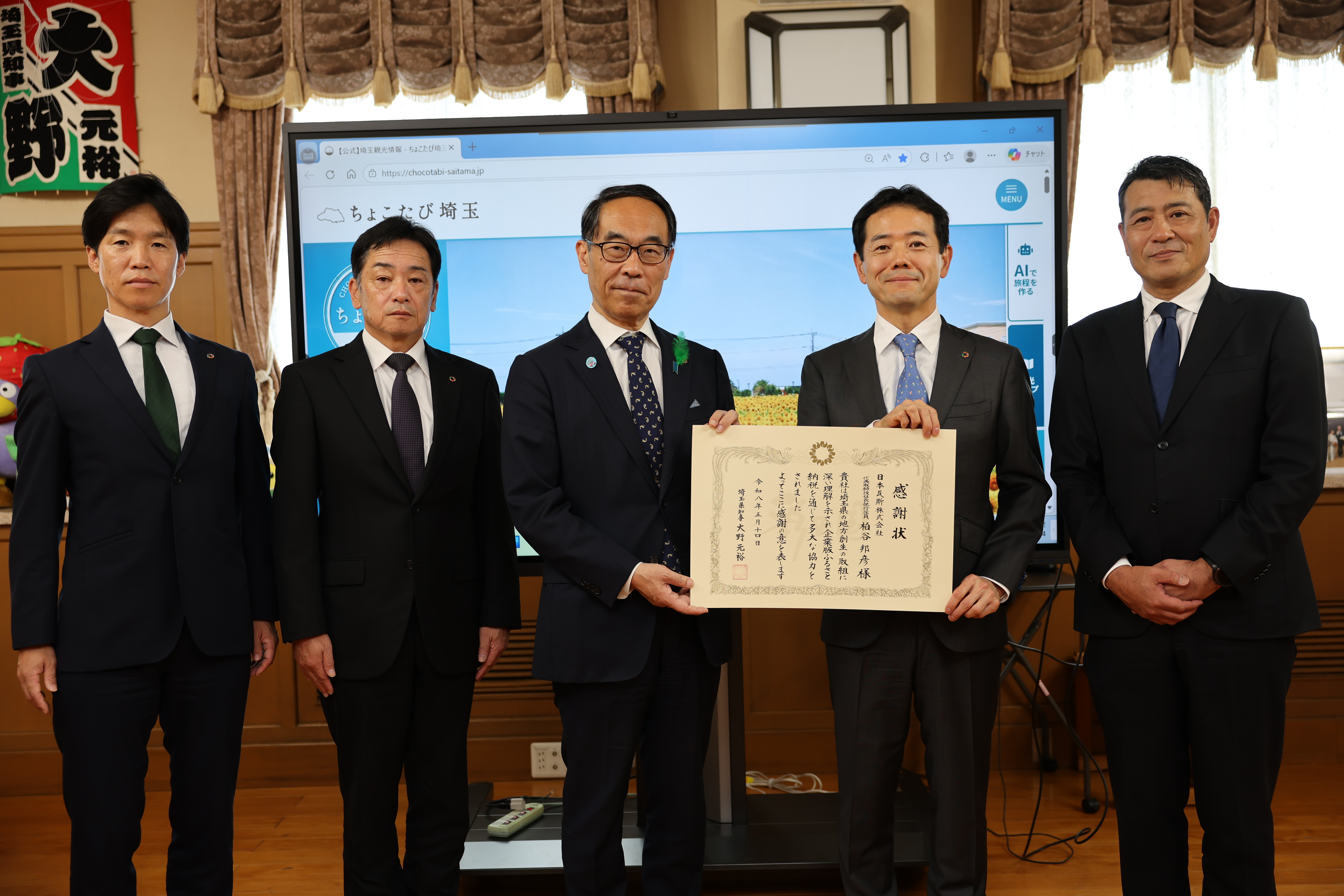 贈呈式出席者と記念写真を撮る知事の写真