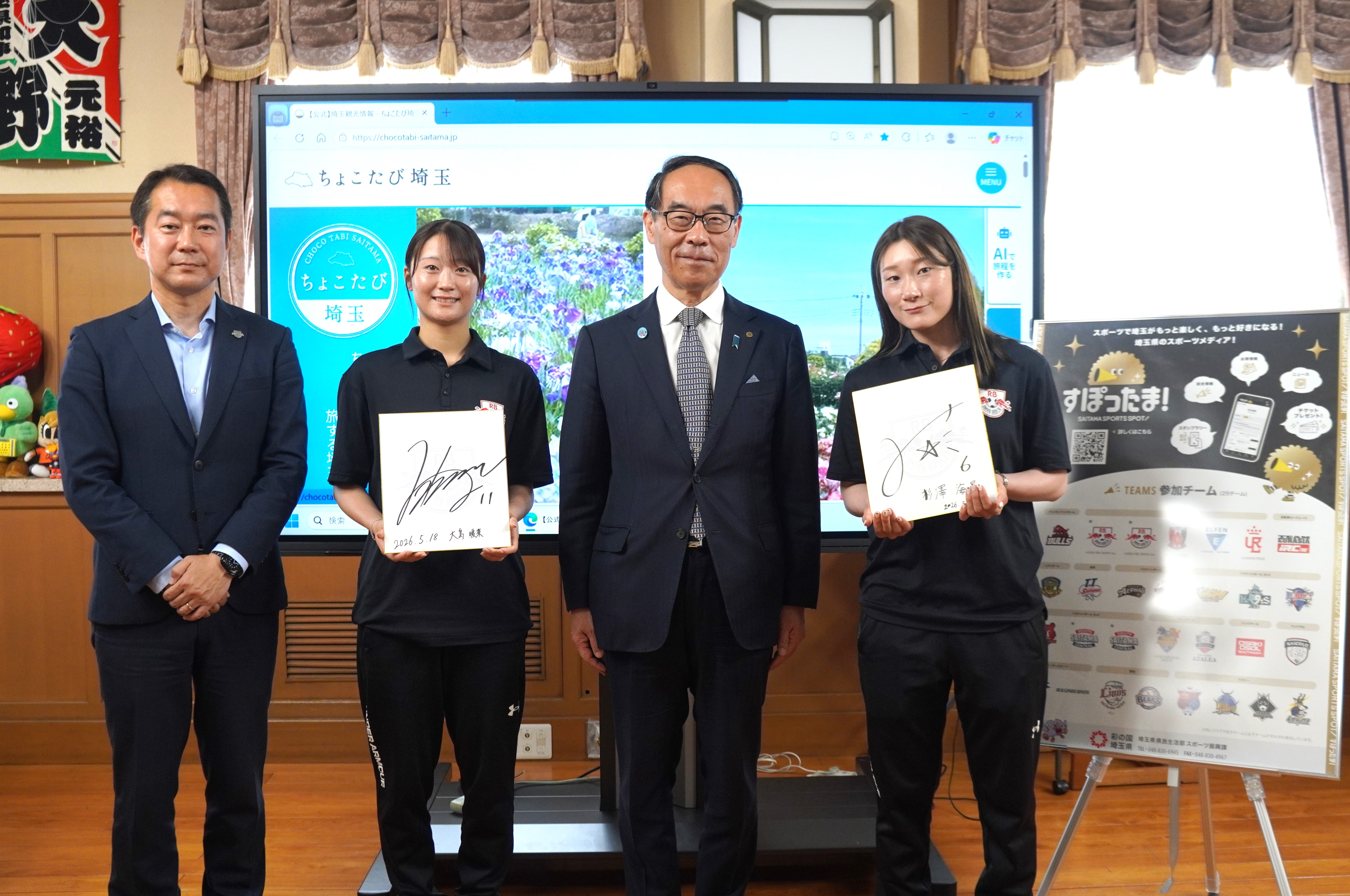 訪問者と記念写真を撮る知事の写真