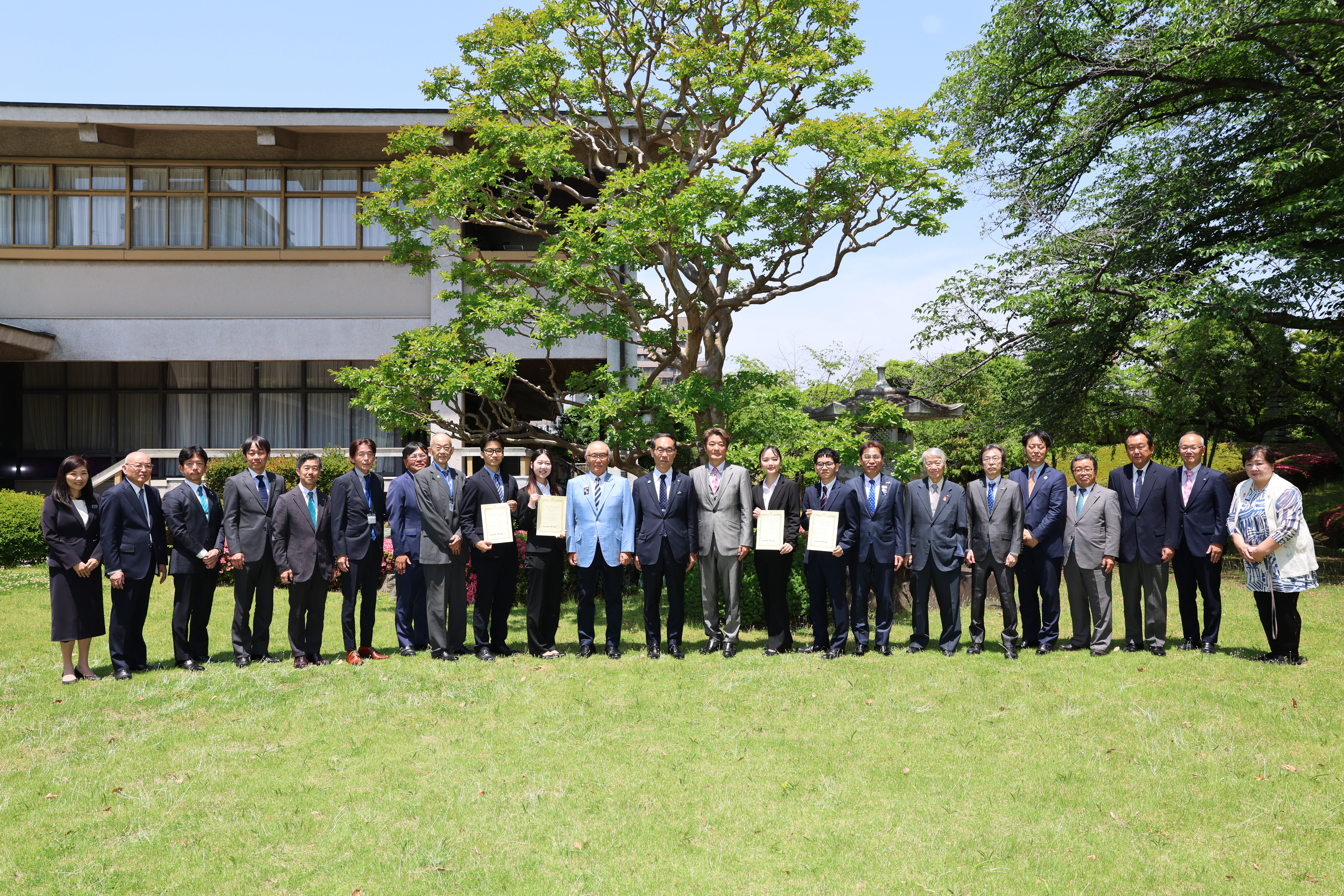 訪問者と記念写真を撮る知事の写真