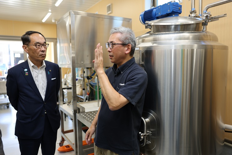 訪問先で説明を受ける知事の写真