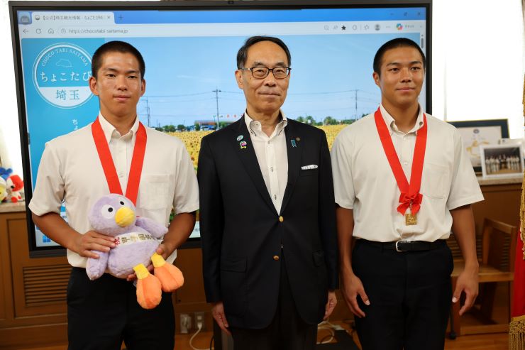 訪問者と記念写真を撮る知事の写真