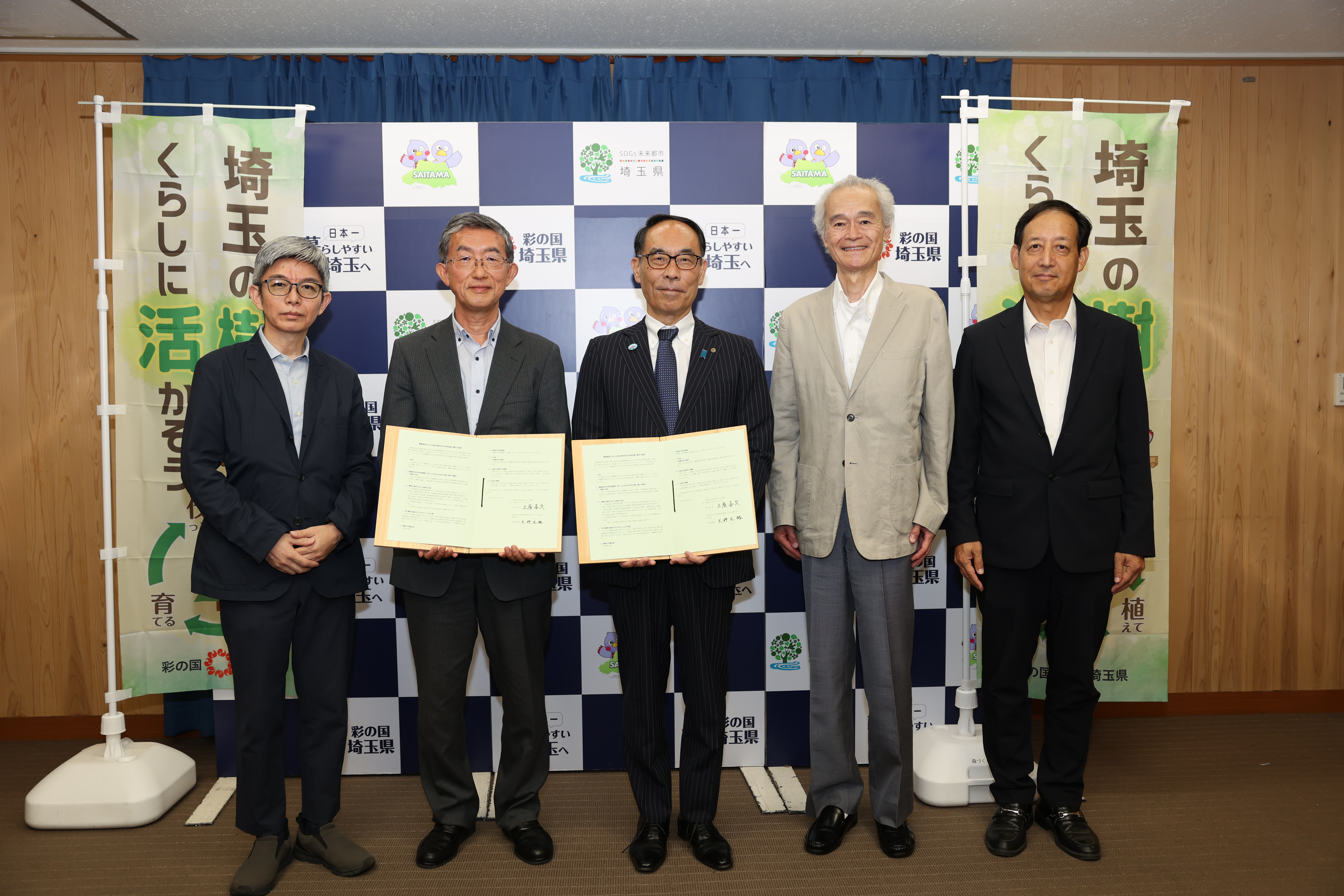 協定締結者と記念写真を撮る知事の写真