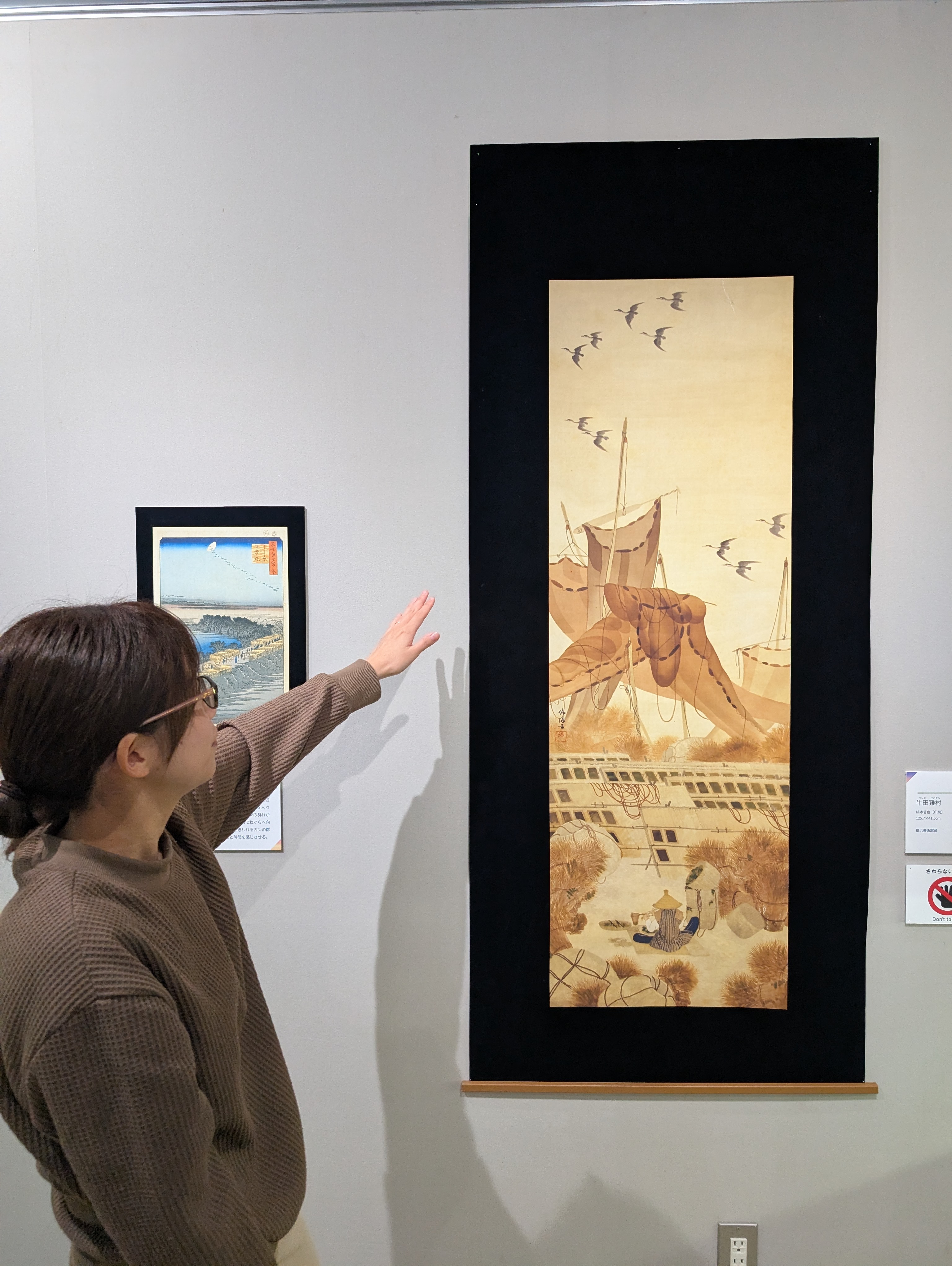 自然の博物館の学芸員が絵画を紹介している様子